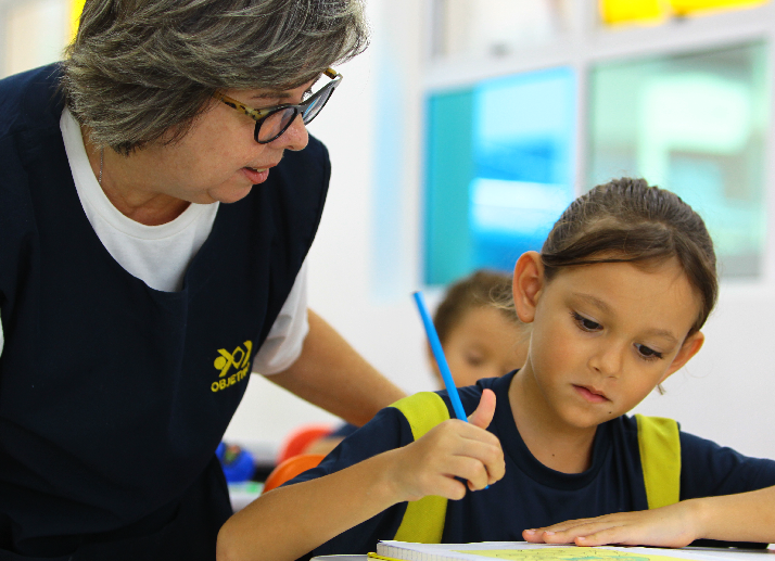 Criança estudando com a professora